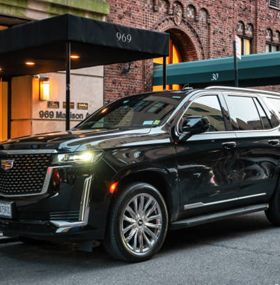 Photo of a Cadillac SUV in front of a brick building