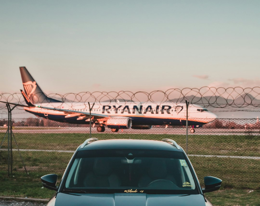 Car parked in front of a gate with razor wire, because it's an airport
