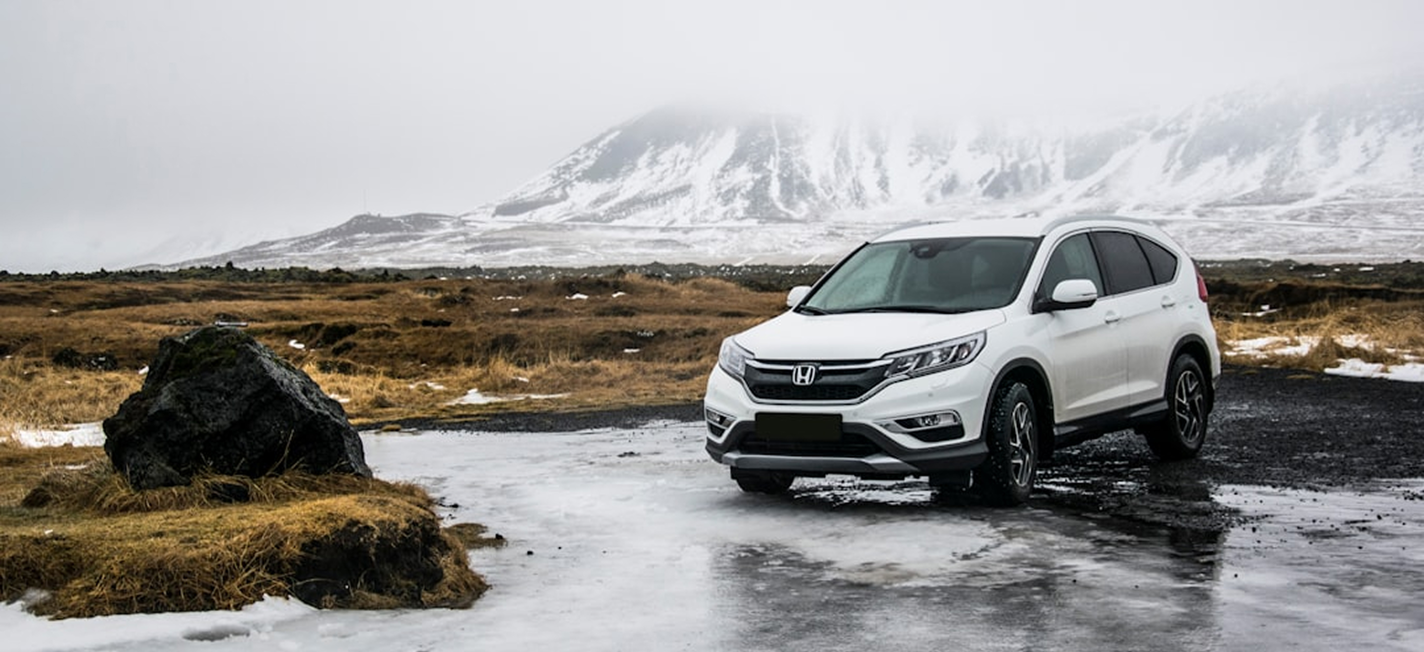 A picture of a Honda CRV in front of a majestic mountain